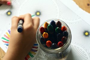 child's hand while doing color