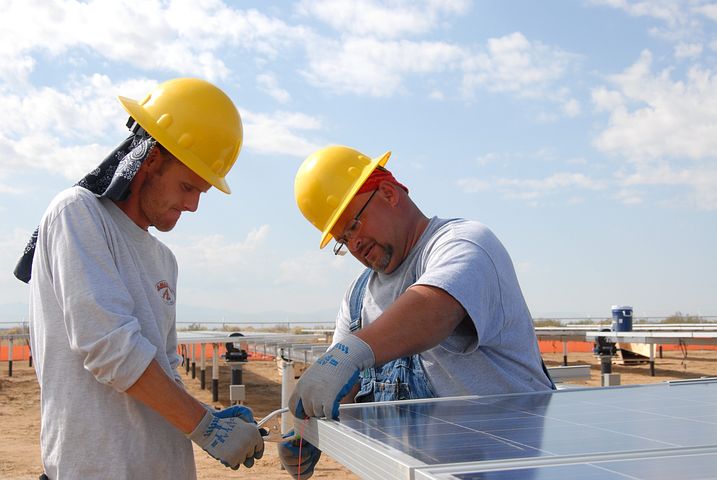 Two people installing 3 phase solar inverter