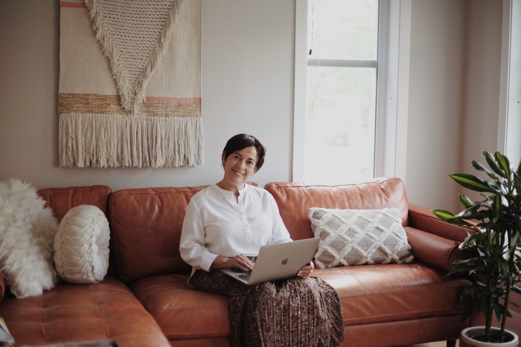 Woman sitting in a leather sofa while using her laptop